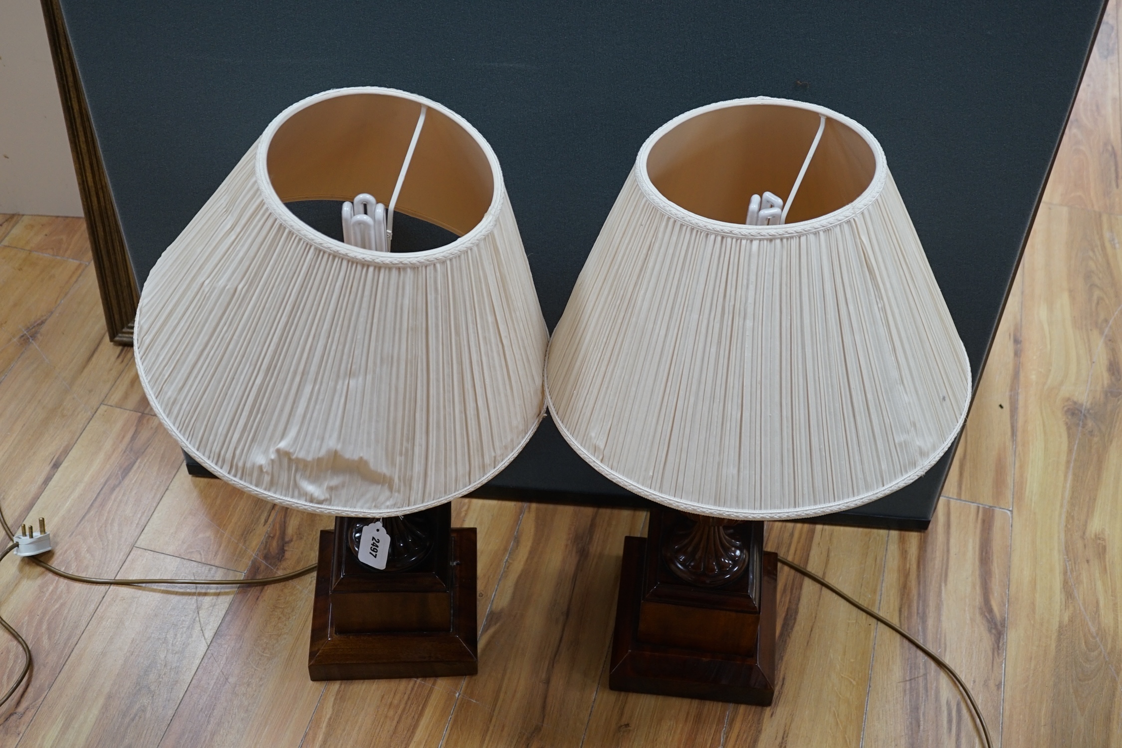 A pair of George III style mahogany carved urn table lamps with shades, 74cm high overall